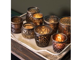 nědý skleněný svícen na čajovou svíčku s kovovým zdobením.